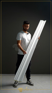 Fațadă albă clasică de magazin cu ancadramente rotunjite, pilastri din poliuretan și vitrine mari de expunere.