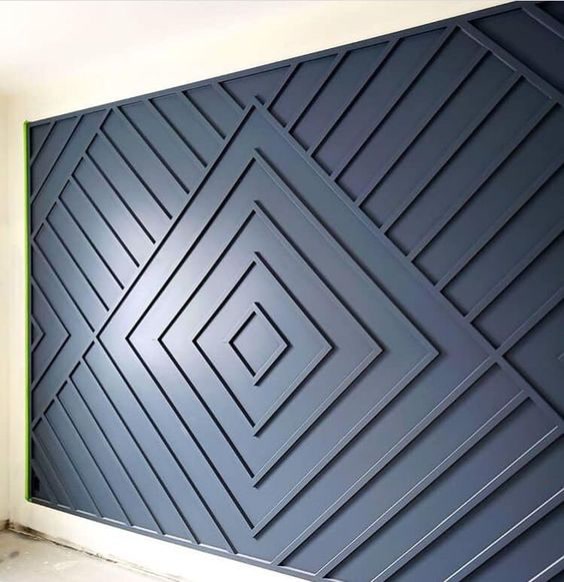 Profil Poliuretan P851350 Pentru Placat Perete Geometric Aplicarea de profile din poliuretan P851350 pe un perete accentuat creează o structură geometrică tridimensională bazată pe romburi concentrice și linii diagonale paralele. Acest tip de placare decorativă reprezintă o soluție tehnică eficientă pentru transformarea suprafețelor plane din spațiile rezidențiale sau comerciale, oferind o rezistență mecanică sporită. Profilele din polimer de înaltă densitate, de aproximativ 150-220 kg/m³ (țintă ~160 kg/m³), garantează o stabilitate dimensională excelentă în timp, fără risc de crăpături sau deformări cauzate de fluctuațiile de umiditate.

Procesul de montaj al profilelor din poliuretan necesită o pregătire riguroasă a suportului și trasarea precisă a axelor de simetrie pe perete. Trasarea începe din centrul compoziției, de unde se debitază profilele la un unghi de 45 grade pentru a forma pătratul central, urmat de extinderea romburilor succesive. Fixarea mecanică și chimică se realiză utilizând adezivi polimerici cu priză rapidă, asamblarea îmbinărilor fiind consolidată cu adeziv special pentru rosturi. Datorită masei reduse a materialului, presiunea pe ancoraj este minimă, simplificând semnificativ munca echipei de montaj pe șantier.

Comparativ cu elementele decorative clasice din lemn sau MDF, poliuretanul dur prezintă o rată de absorbție a apei de sub 1%, fiind imun la mucegai și putrezire. De asemenea, comportamentul termic al materialului între -100 °C / +80 °C permite instalarea în medii cu variații ambientale moderate. Înainte de aplicarea vopselei lavabile pe bază de apă sau poliuretanică, îmbinările se șlefuiesc cu hârtie abrazivă de granulație fină de 240 grit și se sigilează cu un chit acrilic elastic, asigurând o suprafață continuă și omogenă.

Finisarea cromatică a panoului geometric din poliuretan se execută prin pulverizare sau cu rolă de spumă în două straturi succesive de vopsea mată sau satinată. Culoarea închisă accentuează profunzimea reliefului, iar umbrele create de profilul P851350 oferă un efect vizual dinamic sub iluminatul ambiental direct sau indirect. Profilele sunt livrate pre-amorsate din fabrică, optimizând aderența stratului final de vopsea și reducând timpul total de execuție al lucrărilor de finisaj interioare.