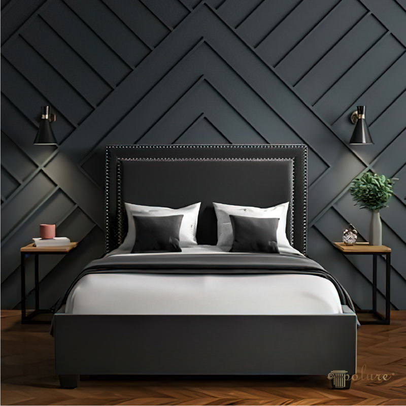 Design Geometric de Perete cu Baghete din Poliuretan Montajul profilului din poliuretan P851350 pe peretele din spatele patului creează o structură geometrică tridimensională în stil chevron, transformând radical aspectul vizual al spațiului fără a încărca structura de zidărie. Profilul din poliuretan cu densitate ridicată, de aproximativ 150-220 kg/m³ (țintă ~160 kg/m³), oferă o soluție tehnică net superioară alternativelor clasice fabricate din ipsos fragil sau din lemn susceptibil la deformare. Datorită rezistenței excelente la impact mecanic și stabilității dimensionale remarcabile la variații de temperatură cuprinse între -100 °C / +80 °C, acest material asigură o durabilitate de lungă durată și previne apariția fisurilor la nivelul îmbinărilor.

Procesul tehnologic de montaj al modelului geometric din imagine începe cu o trasare riguroasă a axelor centrale de simetrie direct pe suportul de zidărie sau gips-carton. Bagheta din poliuretan P851350 se debitează la unghiuri precise de 45 de grade utilizând o cutie de tăiat în unghi sau un ferăstrău mecanic cu disc fin, asigurând îmbinări perfecte la colțuri. Pentru fixare se utilizează adeziv polimeric de înaltă aderență aplicat în linie continuă pe spatele baghetei, urmat de o presare fermă pe perete. În cazul peretelui cu lungimi mari, se aplică și cuie fără floare cu un pistol pneumatic la intervale de 40 cm pentru o stabilizare imediată.

În ceea ce privește proprietățile fizico-chimice, materialul din poliuretan înregistrează o rată de absorbție a apei de sub 1%, aspect ce elimină complet riscul de umflare la contactul cu amorsele și vopselele lavabile pe bază de apă. Închiderea rosturilor dintre baghete se realizează cu un mastic elastomeric acrilic special conceput pentru poliuretan, urmată de o șlefuire fină cu hârtie abrazivă cu granulație de 240 pentru netezirea îmbinărilor. După pregătirea suprafeței, profilele sunt vopsite într-un strat de grund și două straturi de vopsea mată în tonuri închise de antrasit, obținându-se un finisaj omogen și rezistent.

Alegerea sistemelor decorative din poliuretan P851350 reduce timpul de lucru al meseriașilor cu până la 50% față de placările din lemn, scăzând totodată costurile globale ale manoperei pe șantier. Structura ușoară nu aplică tensiuni suplimentare pe perete, fiind potrivită chiar și pentru pereți despărțitori din gips-carton monostrat. Iluminatul direcționat de la aplicele de perete evidențiază relieful creat de liniile diagonale, accentuând efectul tridimensional al compoziției. Rezultatul este un perete accent modern, rezistent la uzură și ușor de curățat în timp.