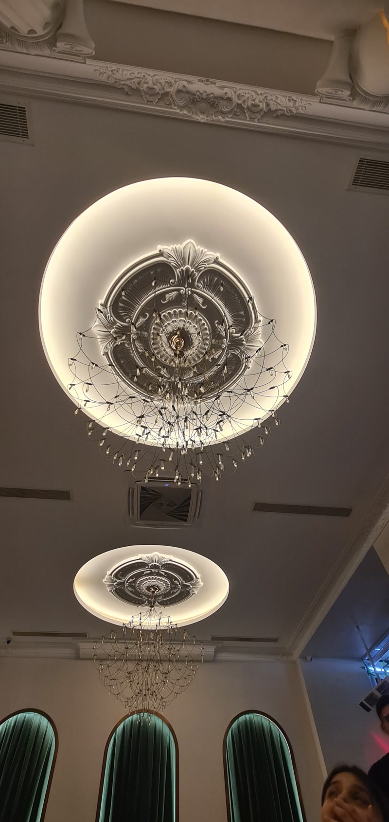 Montaj Elemente Poliuretan Pentru Tavane Decorate și Ancadramente Tavan casetat din poliuretan cu rozetă centrală decorativă și ancadramente pe pereți într-o sală de evenimente.