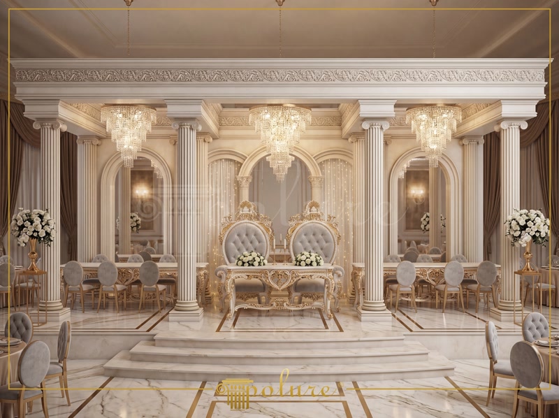 Poliuretan Structuri Coloane și Arcuri Decorative Nuntă Poliuretanul de înaltă densitate (150-220 kg/m³ (țintă ~160 kg/m³)) este un material structural și decorativ optim pentru finisarea spațiilor comerciale de mare anvergură, precum sălile de evenimente și festivități. În structura prezentată, s-a utilizat o combinație de coloane canelate P5830 și P5230I, alături de baze P5930B, pentru a crea un ansamblu portant vizual ce încadrează scena principală. Spre deosebire de ipsosul tradițional, poliuretanul oferă o rezistență mecanică sporită la impact și un coeficient de absorbție a apei de sub 1%, prevenind fisurarea sau degradarea în medii cu umiditate variabilă.

Fixarea sistemelor de arcuri semicirculare P1456D135VI și P1456D160VID pe structurile verticale necesită un adeziv poliuretanic de montaj cu monocomponent și îmbinări mecanice suplimentare cu șuruburi. Profilul de ancadrament P1456 servește drept linie de tranziție între panourile decorative P82210 și zona superioară a cornisei. Procesul de instalare debutează prin trasarea axelor de simetrie, urmată de aplicarea adezivului pe suprafața de contact și fixarea temporară până la polimerizarea completă, asigurând o toleranță dimensională excelentă la temperaturi între -100 °C / +80 °C.

Zonele de fundal ale scenei integrează jumătăți de coloane P5220C și coloane romane scurte P83000C, adaptate direct pe peretele de sprijin pentru a reduce greutatea totală transmisă structurii clădirii. Ancadramentele P1470 înconjoară nișele curbate, creând panouri fundal ideale pentru integrarea iluminatului arhitectural cu LED. Datorită suprafeței pre-amorsate din fabrică, elementele din poliuretan permit aplicarea directă a vopselelor lavabile pe bază de apă, vopselelor acrilice sau a patinei aurii de finisaj, fără a necesita șlefuire agresivă.

Etanșarea rosturilor dintre elementele modulare se realizează cu un adeziv special de îmbinare, urmată de o șlefuire fină cu hârtie abrazivă de granulație 240 pentru eliminarea completă a liniilor de legătură. Această metodă garantează un aspect monolit, fără risc de apariție a fisurilor cauzate de dilatările termice ale clădirii. Alegerea elementelor decorative din poliuretan reduce timpul global de montaj cu peste 60% comparativ cu stucaturile clasice din gips, oferind antreprenorilor o soluție eficientă, durabilă și ușor de întreținut pe termen lung.