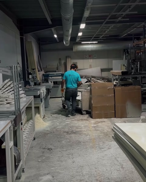 Spațiu de lucru industrial cu profile lungi și piese decorative pregătite.