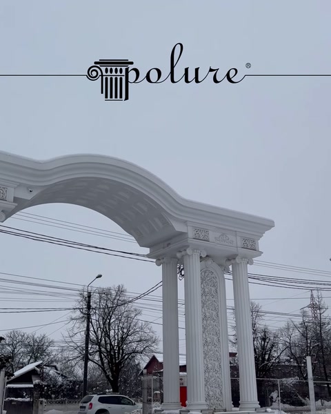 Arcadă decorativă cu coloane albe montată la exteriorul unei clădiri.