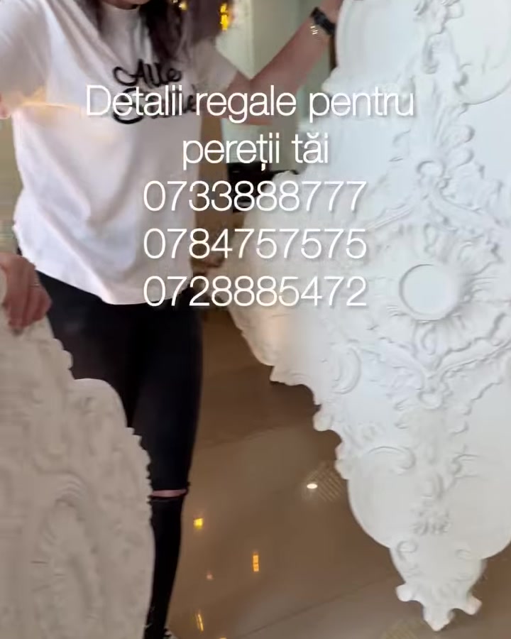 Femeie ține o rozetă mare din poliuretan lângă coloane albe