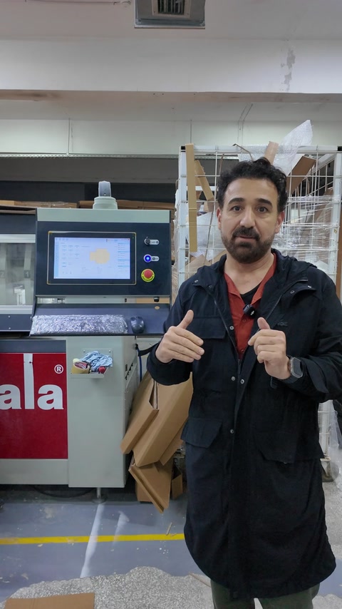 Bărbat arată semnul OK lângă utilajul CNC din producție