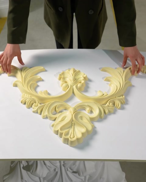 Mâini așază o piesă ornamentală de colț pe masă.