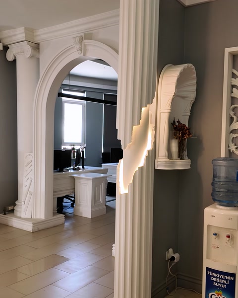Interior de showroom cu arcadă, coloană și profile ornamentale expuse