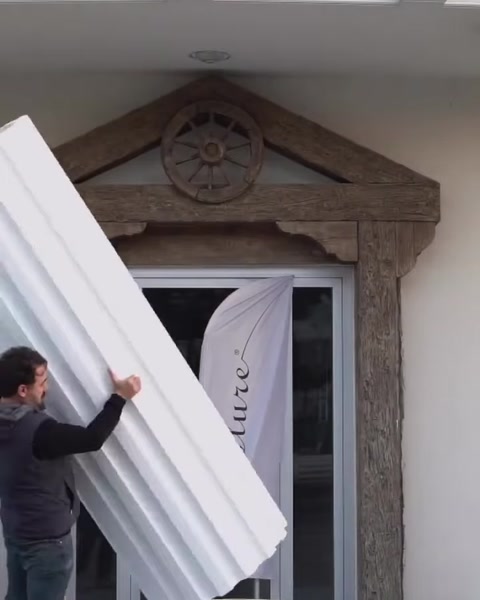 Muncitor aduce un panou de coloană din poliuretan la intrare