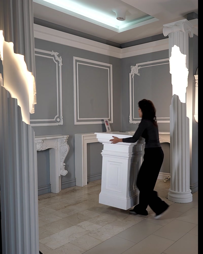 Femeie se apropie de un soclu alb pătrat în showroom