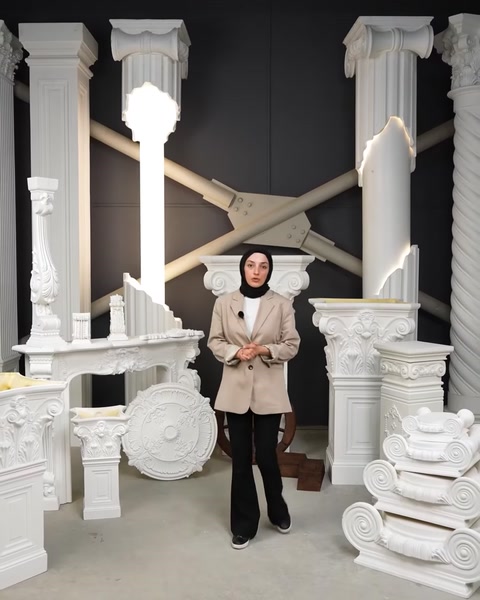 Femeie prezintă gama de coloane și elemente decorative din showroom.