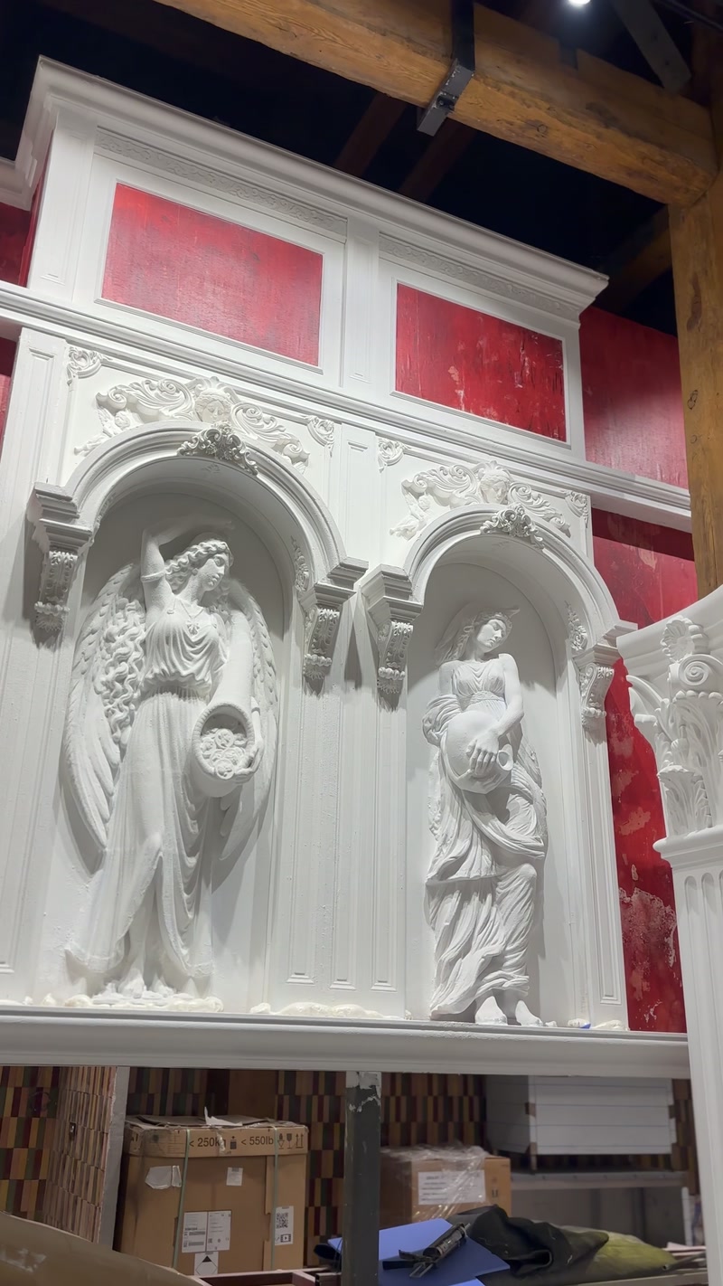 Figură înaripată încadrată de arcadă și profile decorative albe