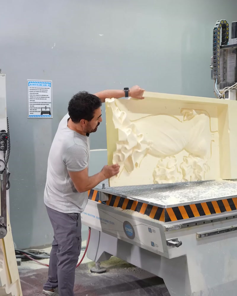 Lucrătorul prelucrează un panou ornamental reliefat pe utilaj CNC