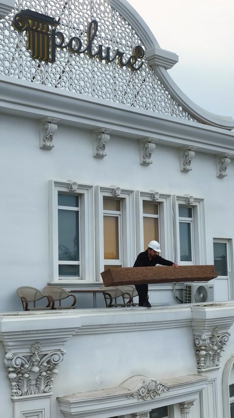 Fațadă albă decorată cu cornișe, coloane și ancadramente reliefate.