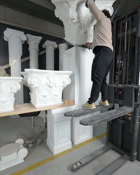 Muncitor urcă pe schelă pentru a instala capitelul pe coloană.