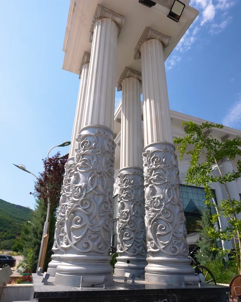 Coloane decorative cu capiteluri ornamentate în prim-plan, finisaj argintiu