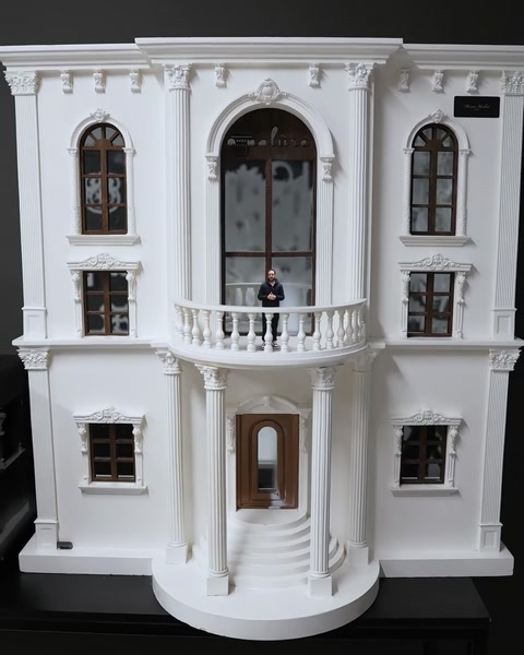 Fațadă completă a clădirii miniaturale cu balcon, ușă și coloane decorative.