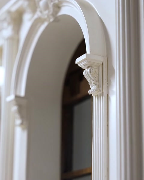 Arc decorativ cu console sculptate montat pe fațada machetei arhitecturale.