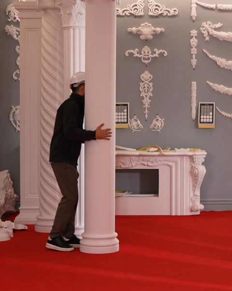 Bărbat sprijină o coloană lângă șemineul ornamentat