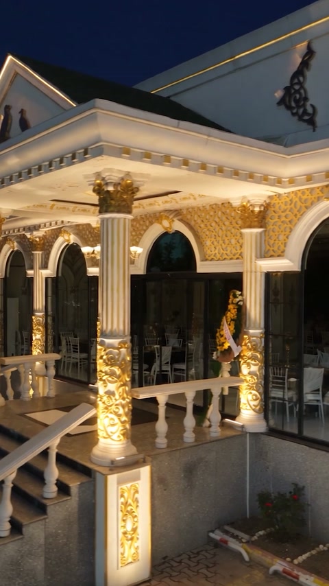 Intrare clasică iluminată, încadrată de coloane canelate și arcade ornamentale