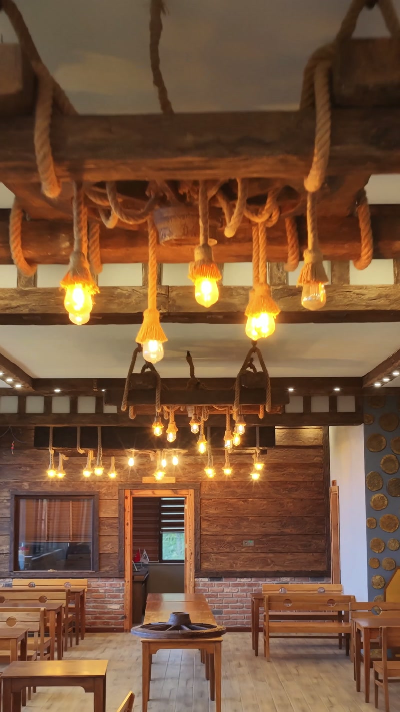 Interior amenajat cu grinzi decorative și corpuri de iluminat rustice