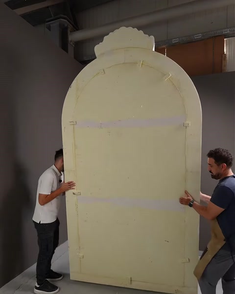 Panoul decorativ este manevrat înaintea montajului în atelier.