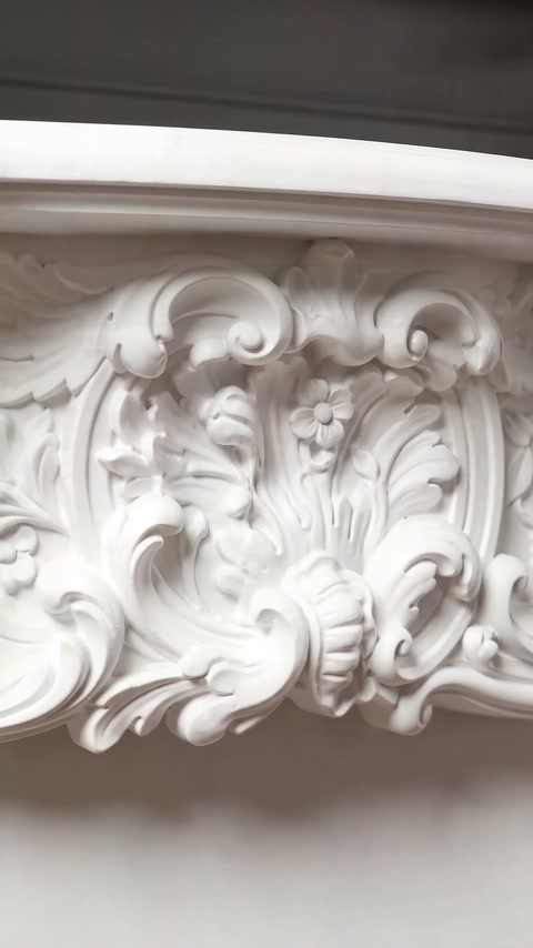 Detaliu apropiat al cartușului rococo cu flori și volute.