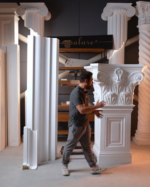 Bărbat aranjează o coloană cu capitel corintic pătrat în showroom