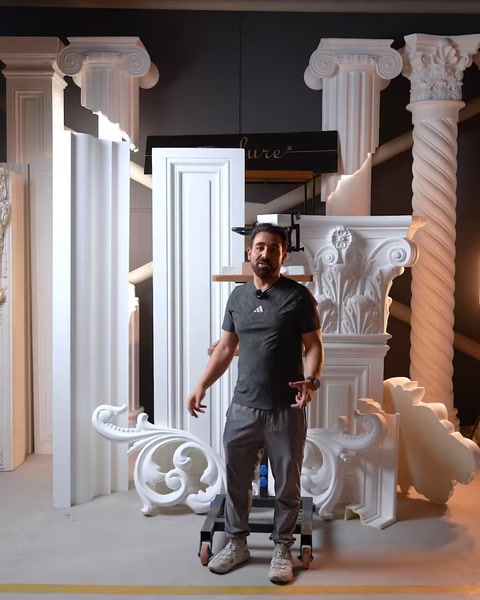 Bărbat pozează lângă capitel și ornament decorativ finalizat în atelier