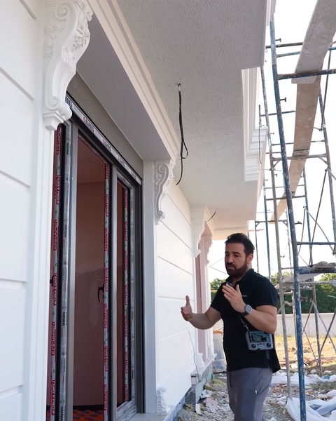 Doi bărbați lângă coloanele de la intrarea vilei finalizate