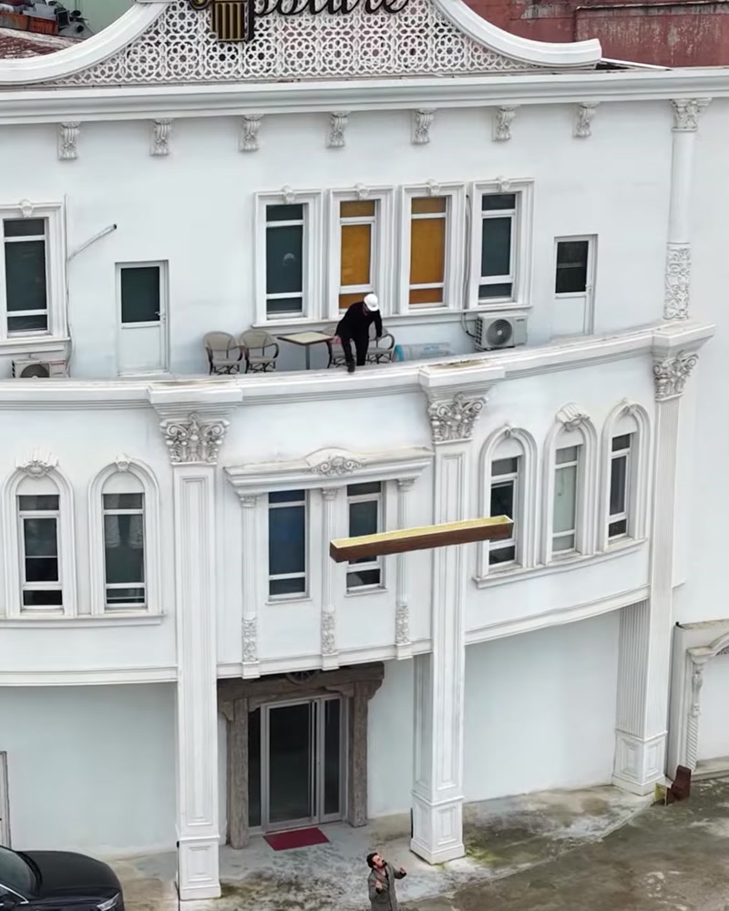 Clădire albă cu grindă decorativă din lemn plutind deasupra intrării