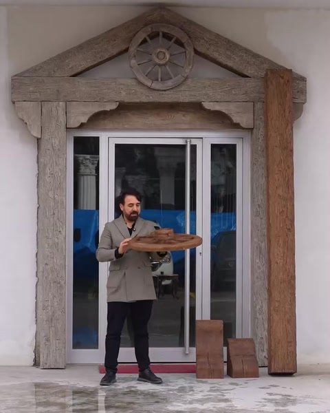 Bărbat ține grindă decorativă din poliuretan lângă ușa de sticlă