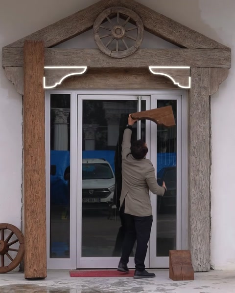 Muncitor montează colț decorativ deasupra ușii, urmând conturul de ghidaj