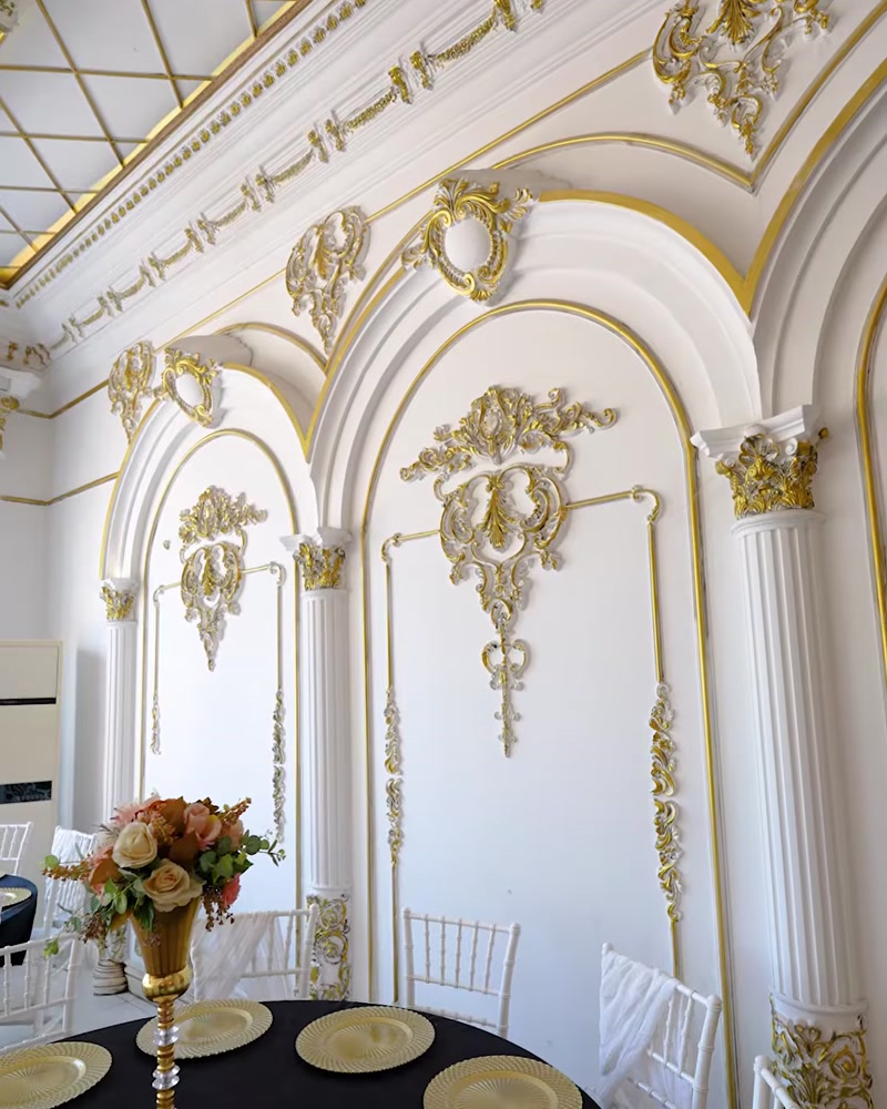 Salon cu coloane și profile decorative albe cu auriu pe pereți