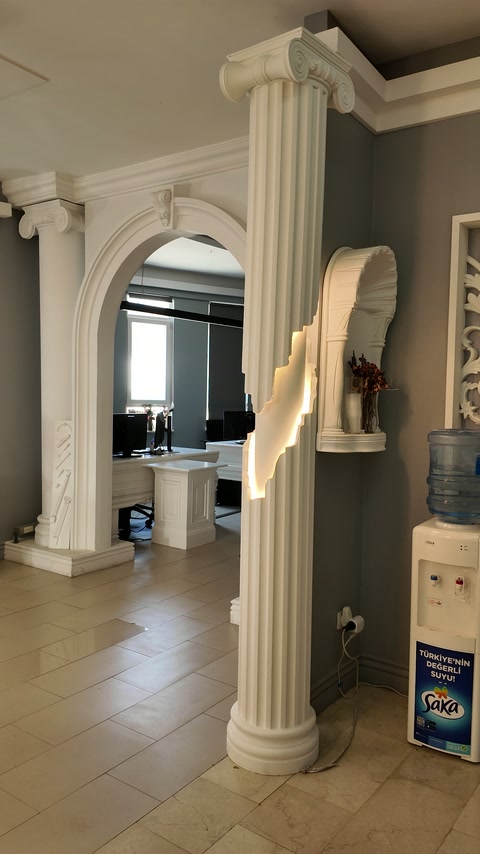Coloană canelată și arc decorativ într-un spațiu amenajat