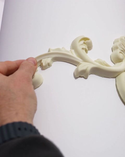 Mâna presează ornamentul flexibil pe profilul rotund al coloanei