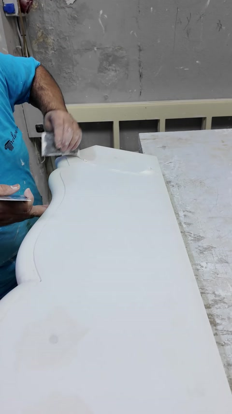 Placa netedă a șemineului este șlefuită pe masa de lucru.