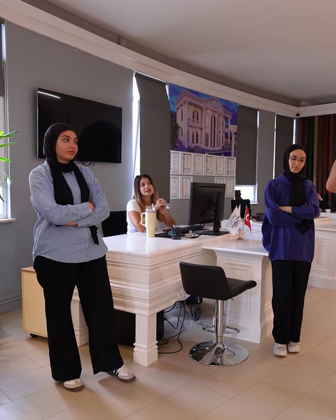 Grup de persoane lângă recepție cu decorațiuni din poliuretan pe pereți