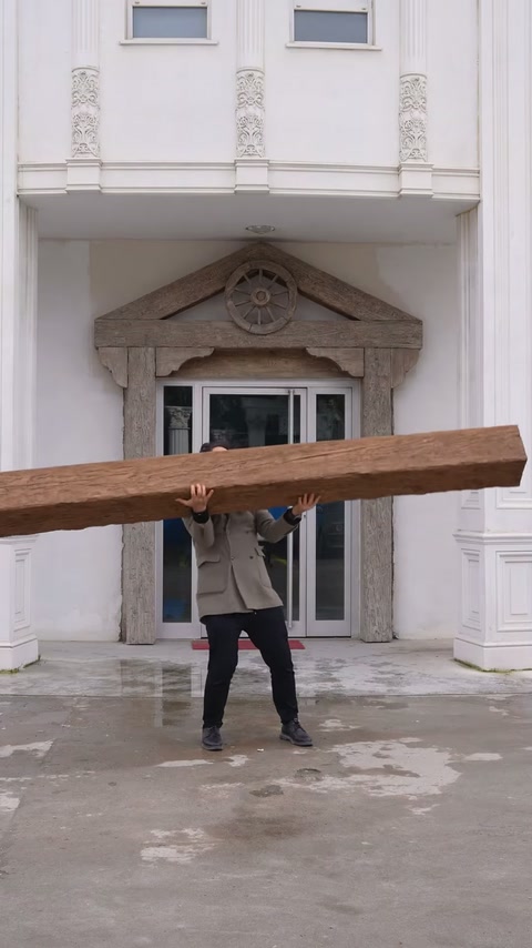 Operator ținând grinda ușoară deasupra capului în exterior